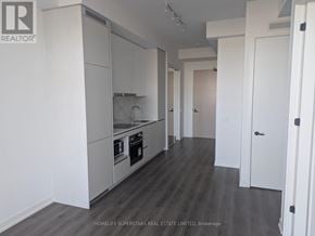 Vaughan (Vaughan Corporate Centre) condo for rent - A modern kitchen with white cabinets and a wooden floor.