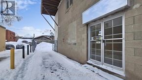 Barrie (City Centre) apartment for rent - A snowy street with a building on the right and a sign that says "RETAIL".