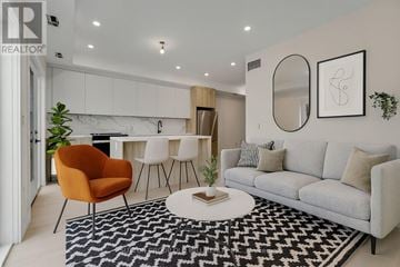 Toronto (Caledonia-Fairbank) multi-family for rent - A living room with a grey sofa, a round orange chair and a black and white rug.