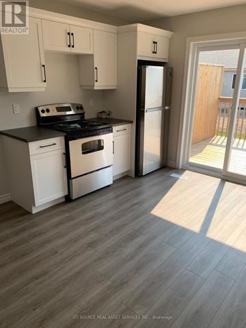 Belleville (Belleville Ward) apartment for rent - A kitchen with white cabinets and a black stove top oven.