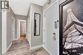 Hamilton condo for rent - A hallway with a door on the right and a picture of the Eiffel Tower on the wall.