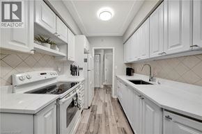 Hamilton condo for rent - A white kitchen with a wood floor and white cabinets.