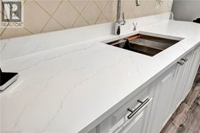 Hamilton condo for rent - A white marble countertop with a sink and a black laptop on it.