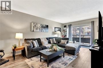 Hamilton condo for rent - A living room with a grey couch, a coffee table, and a painting on the wall.