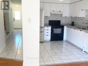 Pickering (Highbush) townhouse for rent - A kitchen with white cabinets and a black oven.