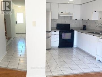 Pickering (Highbush) townhouse for rent - A kitchen with white cabinets and a black oven.