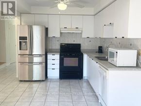Pickering (Highbush) townhouse for rent - A kitchen with white cabinets and a black oven.