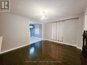 Vaughan (Vellore Village) townhouse for rent - A spacious room with wooden floors and a doorway leading to another room.