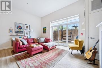 Oakville (Co Central) condo for rent - A living room with a red couch and a guitar.
