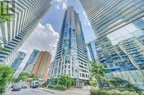 Toronto (Church-Yonge Corridor) condo for rent - A tall glass building stands in the middle of a city street.