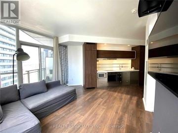 Toronto (Church-Yonge Corridor) condo for rent - A living room with a grey sofa and a television.