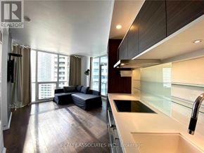 Toronto (Church-Yonge Corridor) condo for rent - A modern kitchen with a large island and a living area with a couch and a bed.