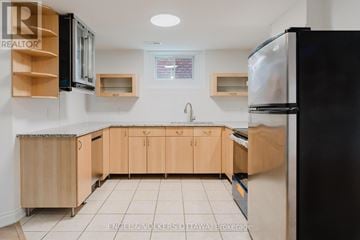 Ottawa apartment for rent - A kitchen with wooden cabinets and a black refrigerator.