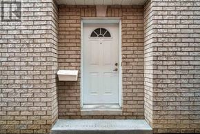 Ottawa apartment for rent - A white door with a glass window in the middle is set in a brick wall.