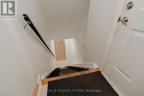 Ottawa apartment for rent - A hallway with a staircase leading to the second floor.