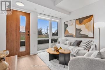 Toronto (Parkwoods-Donalda) townhouse for rent - A modern living room with a grey couch and a wooden door.