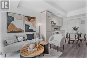 Toronto (Parkwoods-Donalda) townhouse for rent - A modern living room with a grey sofa, a wooden coffee table, and a dining area in the background.