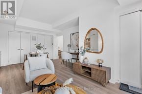 Toronto (Parkwoods-Donalda) townhouse for rent - A well-lit, modern living room with a grey armchair, a wooden coffee table, and a mirror on the wall.