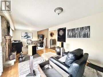 Pickering (Liverpool) apartment for rent - A living room with a black leather couch and a fireplace.