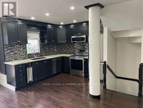 Whitby (Pringle Creek) townhouse for rent - A modern kitchen with dark wood cabinets and a white island.