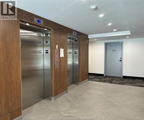 Windsor condo for rent - A hallway with elevators numbered 12, 13, and 14.