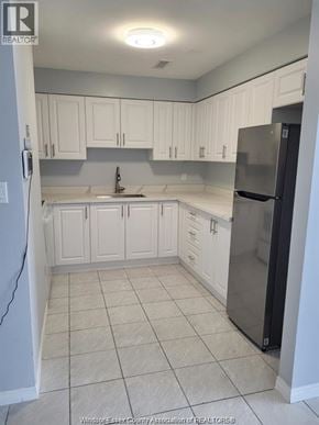 Windsor apartment for rent - A kitchen with white cabinets and a black refrigerator.