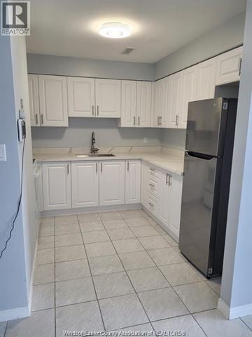 Windsor apartment for rent - A kitchen with white cabinets and a black refrigerator.