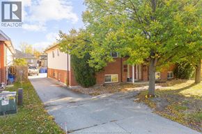 Windsor apartment for rent - A tree in front of a brick building with a sign that says REALTOR.