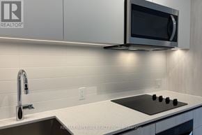 Toronto (Newtonbrook West) condo for rent - A modern kitchen with a black stove top and a silver faucet.