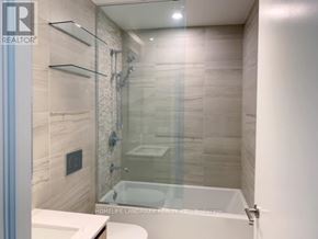 Toronto (Church-Yonge Corridor) condo for rent - A bathroom with a glass shower door and a white tub.