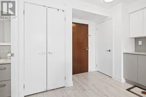 Toronto (Yorkdale-Glen Park) condo for rent - A kitchen with white cabinets and a wooden door.