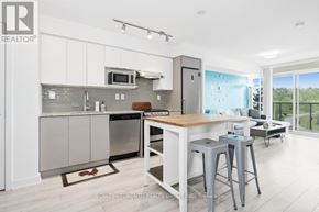Toronto (Yorkdale-Glen Park) condo for rent - A modern kitchen with a breakfast bar and a view of the backyard.