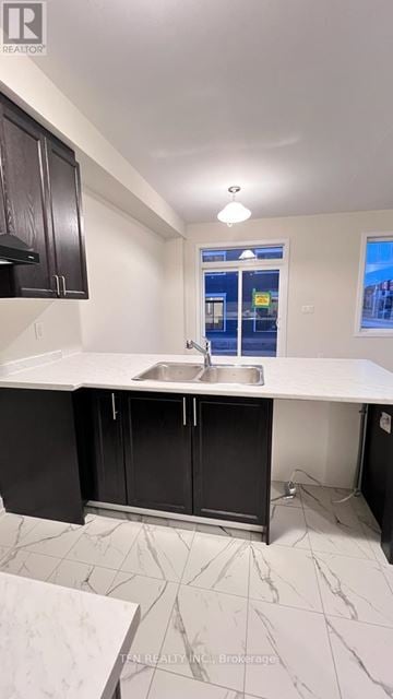 Thorold (Hurricane/Merrittville) townhouse for rent - A kitchen with black cabinets and a white countertop.