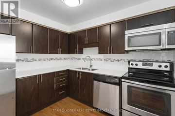 London East (East F) condo for rent - A kitchen with brown cabinets and white appliances.
