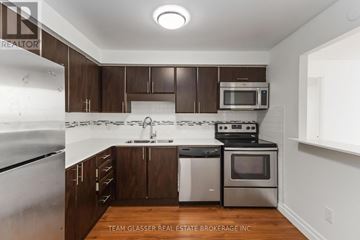 London East (East F) condo for rent - A kitchen with brown cabinets and stainless steel appliances.
