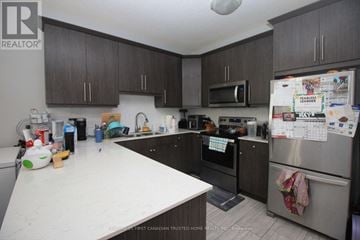 London South (South U) townhouse for rent - A kitchen with a white counter top and a refrigerator with a calendar on it.