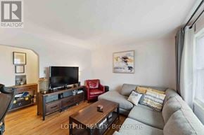 Ottawa duplex for rent - A living room with a grey couch, a red chair, a wooden coffee table, and a television.