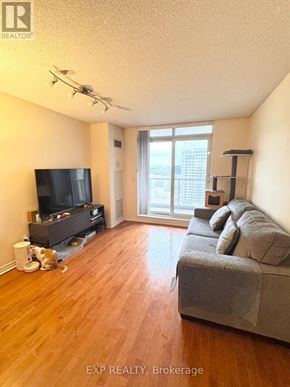 Toronto (Bayview Village) condo for rent - A living room with a grey couch and a television.