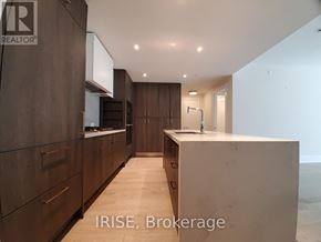 Toronto (Waterfront Communities) condo for rent - A modern kitchen with dark wood cabinets and a white countertop.