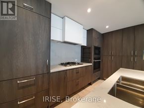 Toronto (Waterfront Communities) condo for rent - A modern kitchen with dark wood cabinets and stainless steel appliances.