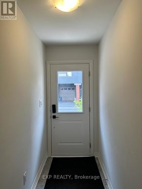 Oshawa (Samac) apartment for rent - A white door with a black handle and a window above it.