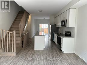 Oshawa (Samac) apartment for rent - A kitchen with white cabinets and a staircase.