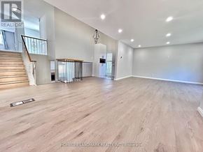 Markham (Unionville) apartment for rent - A spacious room with wooden flooring and a staircase with a metal railing.