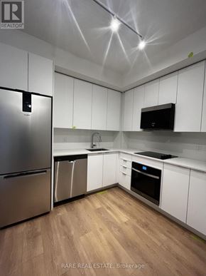 Vaughan (Concord) condo for rent - A kitchen with white cabinets and a stainless steel refrigerator.