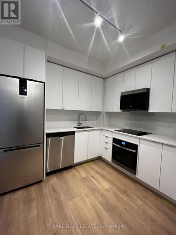 Vaughan (Concord) condo for rent - A kitchen with white cabinets and a stainless steel refrigerator.
