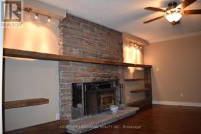 Uxbridge apartment for rent - A living room with a fireplace and a ceiling fan.