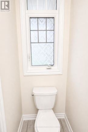 Innisfil (Alcona) townhouse for rent - A white toilet in a bathroom with a window above it.