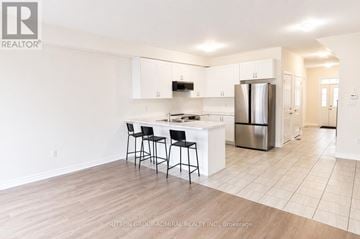 Innisfil (Alcona) townhouse for rent - A kitchen with white cabinets and a black bar stool.