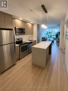Burlington (Orchard) condo for rent - A modern kitchen with stainless steel appliances and wooden flooring.
