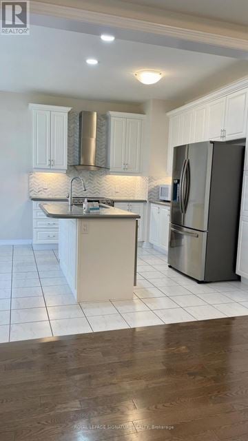 Oakville (Go Glenorchy) apartment for rent - A kitchen with white cabinets and a black fridge.